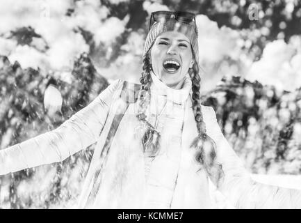 Inverno sul livello superiore di divertimento. sorridente giovane donna in alto adige, italia godendo di nevicata Foto Stock