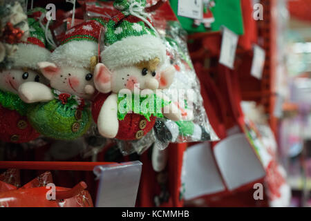 Natale elfi decorativi appeso su un ripiano in un negozio Foto Stock