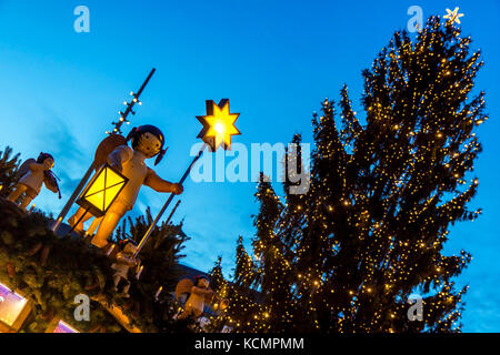 Decorazione del chiosco sotto albero di natale sul mercato di Natale a sera. decorativi ad albero di natale con illuminazione pubblicità di stand. Foto Stock