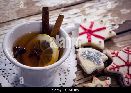 Close-up di tè, le spezie e i cookie sul tavolato in legno Foto Stock