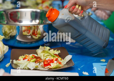 La mano dello chef versando in salsa di insalata giapponese, il processo di cottura, ristorante di concetto Foto Stock
