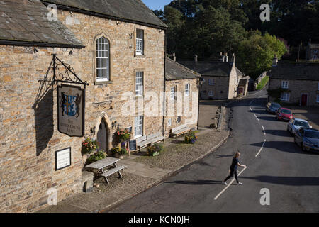 L'A6306 Road passando il Signore Crewe Arms Hotel nel villaggio di Northumbrian di Blanchland il 29 settembre 2017, in Blanchland, Northumberland, Inghilterra. Blanchland è un villaggio del Northumberland, Inghilterra, sulla contea di Durham confine. La popolazione della parrocchia civile al 2011 censimento è stato 135. Blanchland era formata fuori della medievale Abbazia Blanchland proprietà di Nathaniel equipaggio, terzo barone equipaggio, il vescovo di Durham, 1674-1722. Si tratta di un villaggio di conservazione, costruita in gran parte di pietra dai resti dell'Abbazia del XII secolo. Esso dispone di case pittoresche, sullo sfondo di una profonda woo Foto Stock