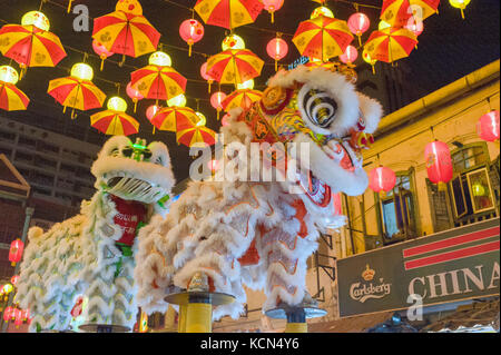 La danza del leone può essere eseguita su una serie di piccole piattaforme circolari a Kuala Lumpur in Malesia Foto Stock