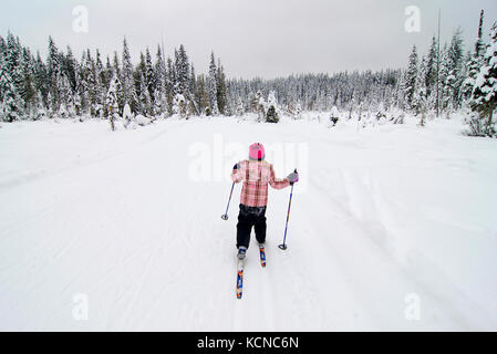 Ragazza giovane (7) gode di una giornata di sci di fondo a colline di larice Nordic Center vicino a Salmon Arm nella regione di Shuswap della British Columbia, Canada Foto Stock