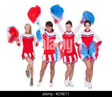 Gruppo di giovani cheerleaders in rosso uniforme. Isolato su sfondo bianco Foto Stock