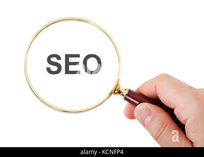 Close-up di mano mostra Seo parola attraverso la lente di ingrandimento su sfondo bianco Foto Stock