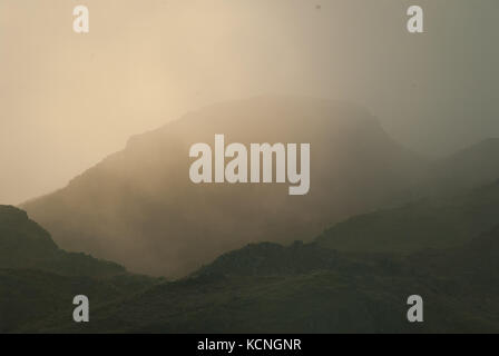 Dawn sopra Loughrigg, con basse nuvole e nebbia, vicino Ambleside, Lake District National Park, Regno Unito Foto Stock