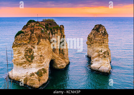 Bel tramonto sul raouche, piccioni' rock. a Beirut, Libano.sun e pietre sono riflesse in acqua.dense nubi nel cielo. Foto Stock