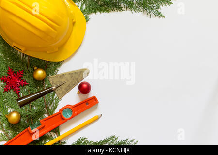 Casco di protezione, mason gli strumenti e le decorazioni di Natale su sfondo bianco Foto Stock