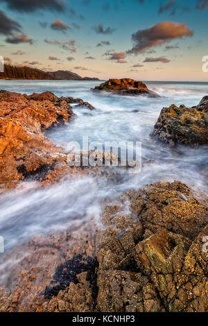 Wild West Coast del Nord dell'isola di Vancouver, CAPE SCOTT, British Columbia, Canada. onde si infrangono lungo il litorale fotografato a lunga esposizione. Foto Stock