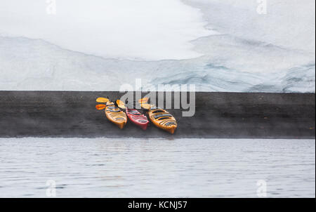 Tre i kayaks allineate sulla spiaggia vulcanica di whalers bay diventare il centro di interesse in un design semplice, isola Deception, a sud le isole Shetland Foto Stock