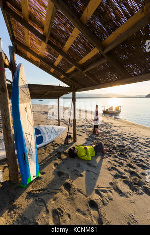 Una coppia con i loro stand up paddle boards rilassa alla fine d'oca Spit parco regionale. Comox, Il Comox Valley Foto Stock