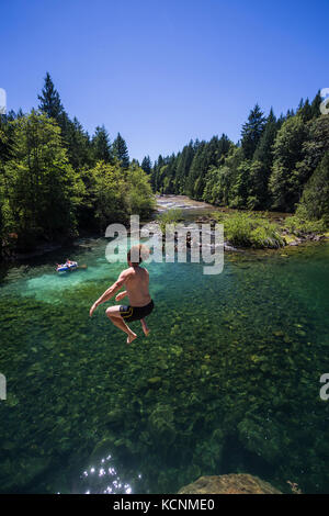 In cerca di sole e nuotatori migrare a barbieri foro lungo il fiume oyster, una popolare area nuoto nella Comox Valley, l'isola di Vancouver, Canada Foto Stock