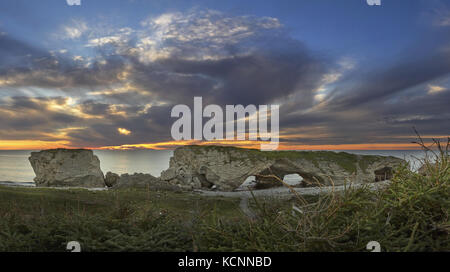 Tramonto attraverso gli archi di pietra calcarea formazione di roccia, gli archi Parco Provinciale, Great Northern Penenusla, Terranova e Labrador Foto Stock