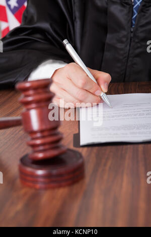 Close-up del Giudice Maschio scrittura su carta nelle aule di tribunale Foto Stock