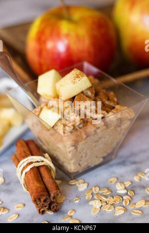 Snack sani di porridge di avena con mele e cannella sulla superficie di marmo Foto Stock