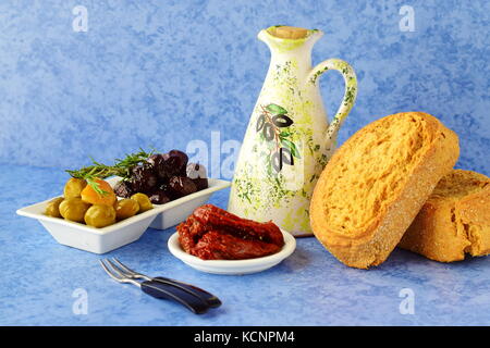 Una serie di piatti della cucina greca: olive, pomodori secchi, limone, barbabietole, jar con olio di oliva e il tradizionale pane secco. piatti greci tradizionali. m Foto Stock