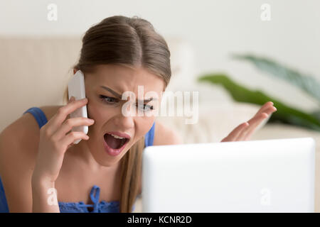 Arrabbiato insoddisfatto giovane donna chiamando il servizio di assistenza clienti o mobile banking, orinato cliente lamenta cattivo servizio, sostenendo sul telefono, avente c Foto Stock