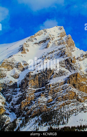 Kananaskis montagne parte della Canadian Rockies. Robusto e rocciose, montagne maestose, contro un profondo cielo blu, come essi si elevano al di sopra della linea di albero. Kananaskis Parco Provinciale, Alberta, Canada. Foto Stock