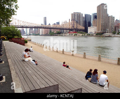 New york, Stati Uniti d'America - 1 luglio - 2016 persone in appoggio in Roosvelt Island con ponte Queensborough Foto Stock