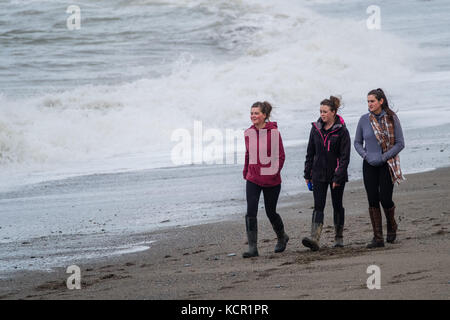 Aberystwyth Wales UK, sabato 07 ottobre 2017 uk meteo: tre giovani donne a piedi lungo la spiaggia su una torbida e breezy pomeriggio autunnale in aberystwyth wales Photo credit: keith morris/alamy live news Foto Stock