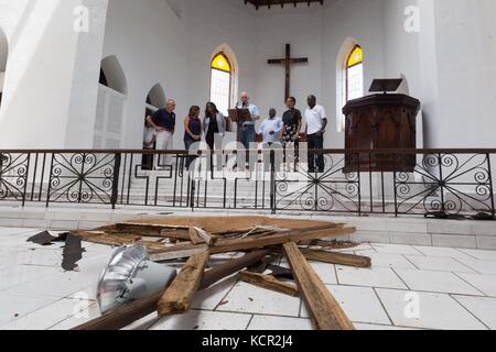 Il Vicepresidente degli Stati Uniti Mike Pence e sua moglie Karen Pence in piedi vicino ai danni della tempesta parlano con i parrocchiani della chiesa episcopale di Holy Cross il 6 ottobre 2017 a Christiansted, St. Croix, Isole Vergini americane. Pence è nelle Isole Vergini per assistere agli sforzi di soccorso dopo la distruzione dell'uragano Maria. Foto Stock