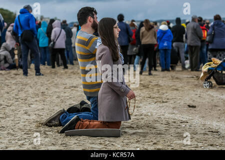 Danzica, Polonia. 7 ottobre 2017. I cattolici che si inginocchiano e pregano un rosario sulla riva del Mar Baltico si vedono a Danzica, in Polonia, il 7 ottobre 2017 i cattolici polacchi sono stati invitati a partecipare a una preghiera rosaria lungo il confine di countryÕs di 3.500 chilometri per pregare per "la loro patria e il mondo intero”. Il 7 ottobre è celebrato nella Chiesa cattolica romana come festa della Madonna del Rosario. Un totale di 319 chiese vicine ai confini polacchi sono state selezionate come punti di incontro per l'evento. Crediti: Michal Fludra/Alamy Live News Foto Stock