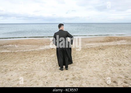 Danzica, Polonia. 7 ottobre 2017. Il sacerdote cattolico che prega un rosario sulla riva del Mar Baltico si trova a Danzica, in Polonia, il 7 ottobre 2017 i cattolici polacchi sono stati invitati a partecipare a una preghiera rosaria lungo il confine di countryÕs per 3.500 chilometri per pregare per "la loro patria e il mondo intero”. Il 7 ottobre è celebrato nella Chiesa cattolica romana come festa della Madonna del Rosario. Un totale di 319 chiese vicine ai confini polacchi sono state selezionate come punti di incontro per l'evento. Crediti: Michal Fludra/Alamy Live News Foto Stock