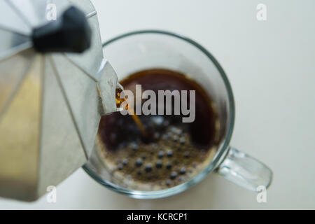 Versare il caffè da moka pot di coppa in vetro Foto Stock