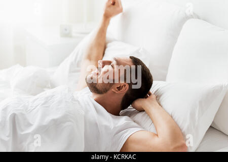 Uomo disteso nel letto di casa Foto Stock