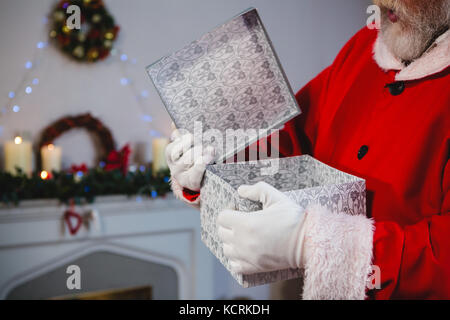 Sezione centrale di santa claus aprendo la confezione regalo Foto Stock