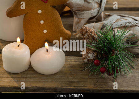 Close up gingerbread cookie con forma a stella di decorazione e acceso candele sul tavolo di legno Foto Stock