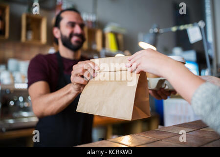 Uomo o il barista che serve il cliente presso la caffetteria Foto Stock