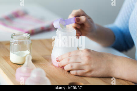 Donna che prepara latte in polvere per neonati in ambienti chiusi, primo  piano. Latte per bambini Foto stock - Alamy