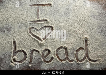 Close-up della parola io amo il pane scritto su cosparso di farina Foto Stock