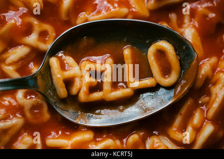 La parola "hello" su un cucchiaio di farro spaghetti in alfabeto lettere Foto Stock