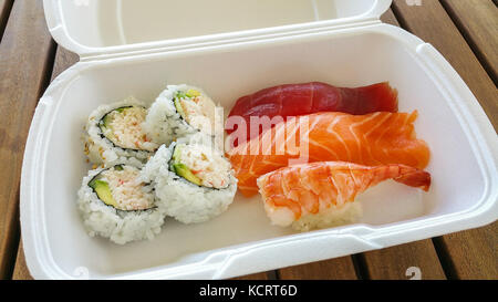 Una deliziosa varietà di sushi per andare casella sul tavolo. Foto Stock