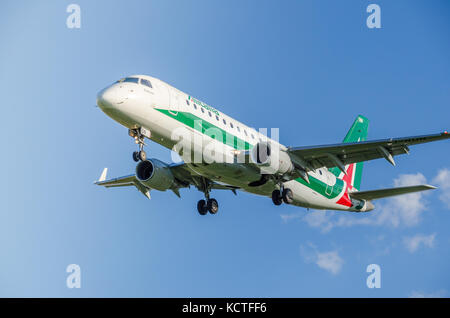 Un alitalia embraer e175lr cityliner aeroplano contro un cielo blu. Questi piani operano voli a breve raggio in Italia e in Europa Foto Stock