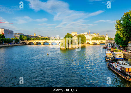 La punta dell'Île de la Cité al tramonto attrae folle di persone a sedersi sulle sponde del Fiume Senna a Parigi, Francia Foto Stock