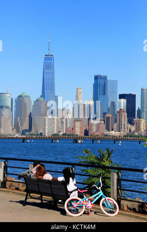 I visitatori si rilassano sulla passeggiata sul lungomare del fiume Hudson con lo skyline di Lower Manhattan sullo sfondo.New York City/New Jersey, USA Foto Stock