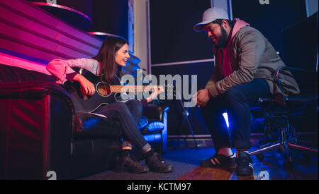 L uomo e la donna di comporre una canzone sulla chitarra. Artisti del suono in studio di registrazione. Foto Stock