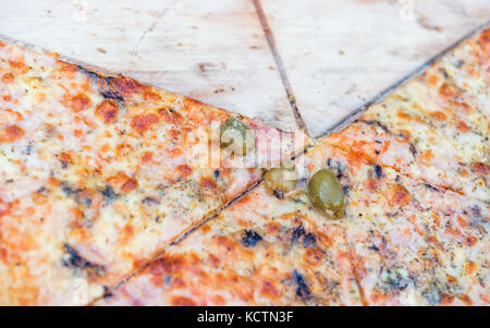 Fette di Pizza su un tagliere di legno, fuoco selettivo Foto Stock