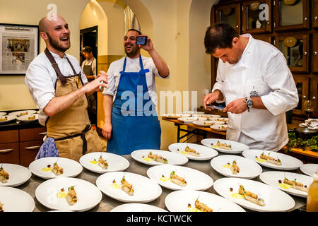 Realizzazione divertente quando guardate in su dal vostro telefono delle cellule. Gli chef Michelin Star Klaus Erfort (r.) e Simon Stirnal (l.) scattano foto in cucina Foto Stock