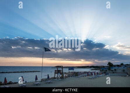 Sunbeam scoppiare attraverso da dietro le nuvole a Coral Bay in Peyia distretto, vicino a Paphos, Cipro. Stock Photo Burst di raggi solari attraverso da essere Foto Stock