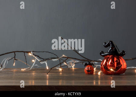 Accessori di decorazioni happy Halloween festival del concetto di sfondo.mix varietà zucche e illuminazione della lampadina sul moderno rustico in legno marrone a off Foto Stock