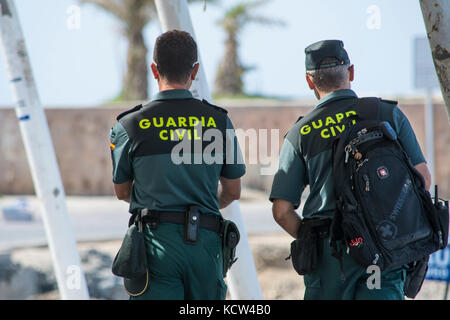 Due Guardia civile spagnola (Guardia civile) ufficiali pattugliano il porto sull'isola spagnola di Tabarca Foto Stock