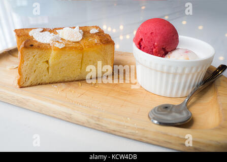 Pane tostato miele messo sul piatto di legno con gelato allo yogurt e gelato fragola. collocato su un marmo bianco tavola. Foto Stock