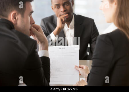 Vista posteriore di pensosa hr manager lettura, discutendo i candidati riprendere, preoccupato african american job ricorrente in attesa decisione in intervista su BAC Foto Stock