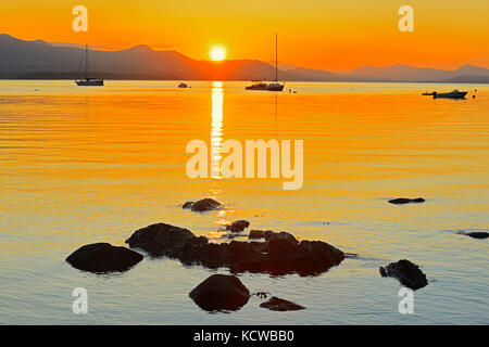 Barche a vela al tramonto sulla baia del Vesuvio. Guardando ad ovest a Crofton sull'Isola di Vancouver. , Isola di Saltspring (Isole del Golfo), British Columbia, Canada Foto Stock