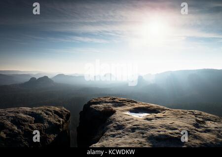 Molla blu alba. scogliera di arenaria al di sopra di una profonda valle misty in Sassonia svizzera. picchi collinare fuori dalla nebbia sreamy. Foto Stock